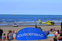 Twee personen uit water gehaald, traumahelikopter landt op strand De Koog