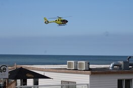 Twee personen uit water gehaald, traumahelikopter landt op strand De Koog