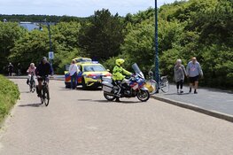 Fietster maakt koprol na afwaaien pet op Badweg in De Koog